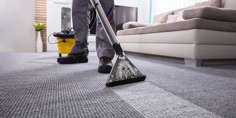 Dùng máy hút bụi để vệ sinh thảm sàn
